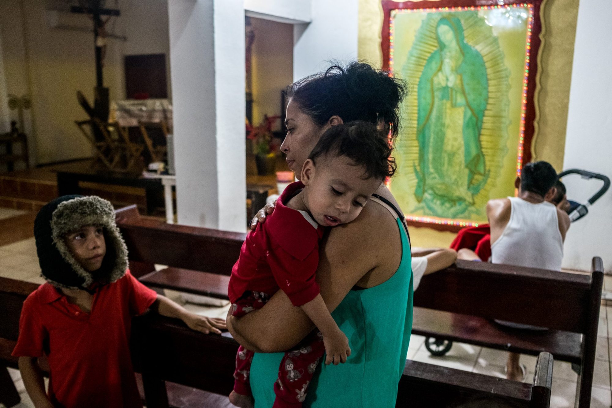 A mother and her two children standing in a church.